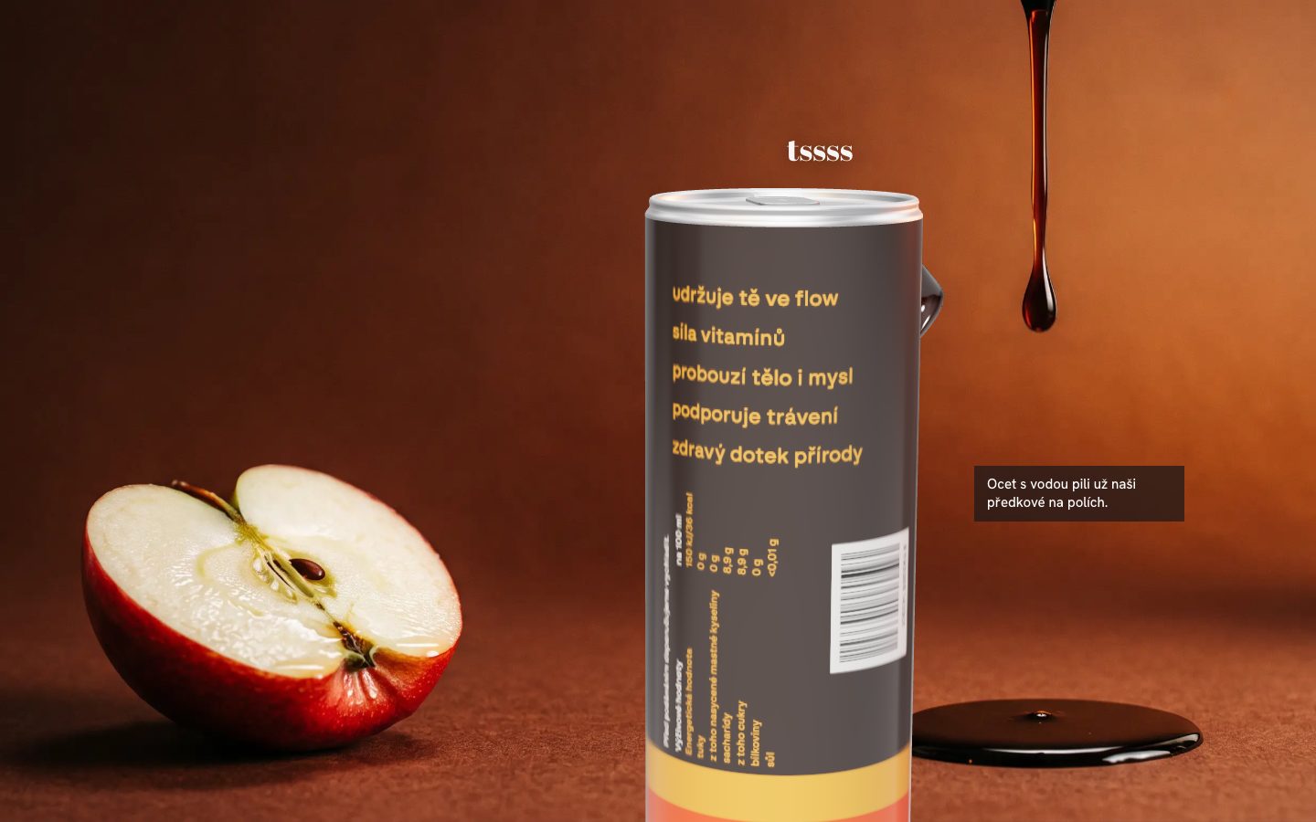 Víčko plechovky QINO zblízka, vedle půlka jablka a kapka balsamika